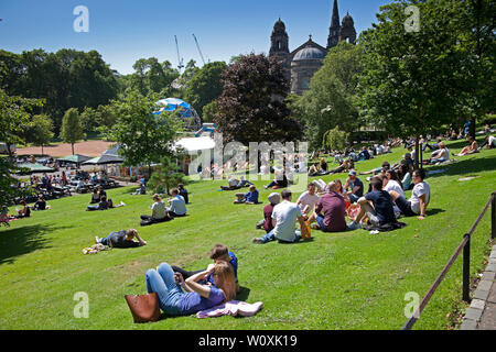 Princes Street Gardens und Edinburgh, Schottland. Juni 2019. Volle Sonne in der Stadt, die von Büromitarbeitern und Besuchern genossen wird, 14 Grad am Morgen mit kühlem Wind, der am Nachmittag auf 17 Grad ansteigt und ein entspannendes Sonnenbad zur Mittagsstunde ermöglicht. Stockfoto