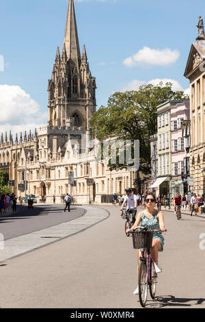 Suche entlang der High Street in Richtung der Kirche St. Maria als Radfahrer entlang an einem schönen, sonnigen Sommer in die berühmte Universitätsstadt Oxford. Stockfoto