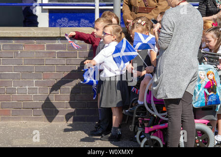 Schule Kinder halten Fahnen während der Königin Besuch Greenfaulds High School in Cumbernauld. Königin Elizabeth II. ist der Besuch Greenfaulds High School in Cumbernauld als Teil einer Woche der Royal Engagements über Schottland. Stockfoto