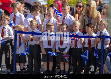 Schule Kinder halten Fahnen während der Königin Besuch Greenfaulds High School in Cumbernauld. Königin Elizabeth II. ist der Besuch Greenfaulds High School in Cumbernauld als Teil einer Woche der Royal Engagements über Schottland. Stockfoto