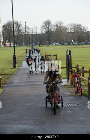 Radfahrer und Fußgänger überqueren Parker's Piece im Zentrum von Cambridge 2019 Stockfoto