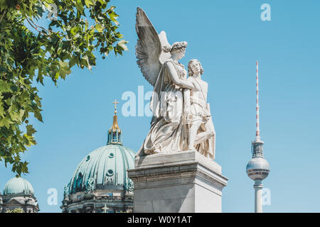 Berlin, Deutschland - Juni, 2019: Die Statue Nike die verwundeten Krieger mit Fernsehturm (Fernsehturm) und der Berliner Dom im Hintergrund unterstützt Stockfoto