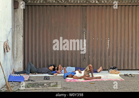 Jakarta, dki Jakarta/Indonesien - 28. Mai 2010: Obdachlose Bau Wanderarbeitnehmer an einem strassenrand vor verschlossenen Shop schlafen auf Jalan kunir in Stockfoto