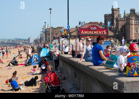 Portobello, Schottland, Großbritannien. 28 Juni, 2019. Warme Temperaturen und ununterbrochenen Sonnenschein brachte Hunderte von Menschen und Familien diesem berühmten Strand ausserhalb von Edinburgh zu genießen. Promenade an der Portobello ist besetzt mit Familien. Credit: Iain Masterton/Alamy leben Nachrichten Stockfoto