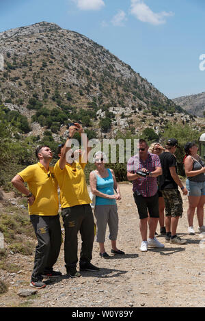 Kreta, Griechenland, Juni 2019. Reiseleiter tragen gelbe Hemden als Team arbeiten und Spaß mit Ihrer Gruppe Stockfoto