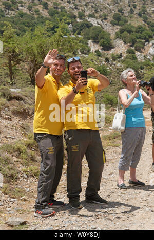 Kreta, Griechenland, Juni 2019. Reiseleiter tragen gelbe Hemden als Team arbeiten und Spaß mit Ihrer Gruppe Stockfoto