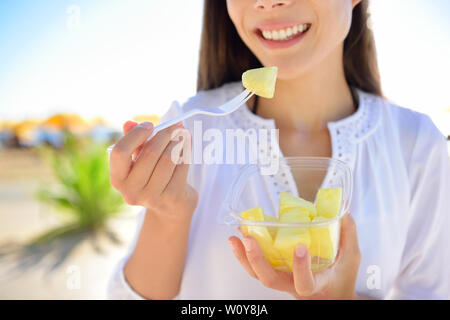 Ananas - Frau essen geschnitten Hawaiianische Ananas Obst als gesunder Snack aus der Schüssel nehmen. Stockfoto