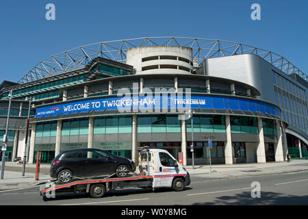 Ein Abschleppwagen, fährt ein Auto ein willkommenes Zeichen in Twickenham Stadium, Twickenham, Middlesex, Twickenham, England Stockfoto