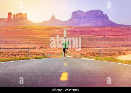 Zweiter Mann Athlet läuft das Sprinten auf der Straße von Monument Valley. Konzept mit sprinter Training für den Erfolg. Fit Sport Fitness Muster in erstaunliche Landschaft Natur arbeiten. Arizona, Utah, USA. Stockfoto