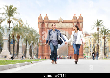 Romantisches Paar dating Spaß in Barcelona läuft lachend im Freien auf. Junge, urbane, schönes Paar genießen das Leben in Barcelona, Spanien in der Nähe von Arc de Triomf auf dem Passeig de Sant Joan. Stockfoto