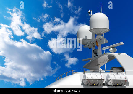 Detail der Luxus weißen Yacht mit Navigation, Radar, Antennen und Rettungsboote auf blauen Himmel mit Wolken Stockfoto