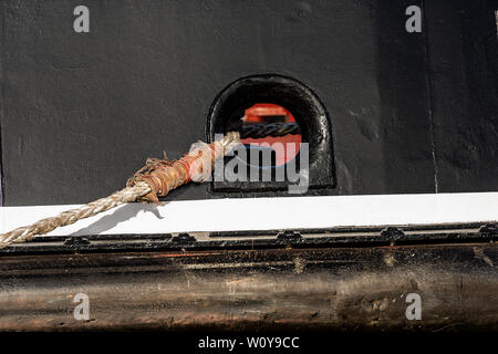 Hawsehole - Detail einer Verankerung Loch mit Seilen, schwarzen Schiff im Hafen Stockfoto