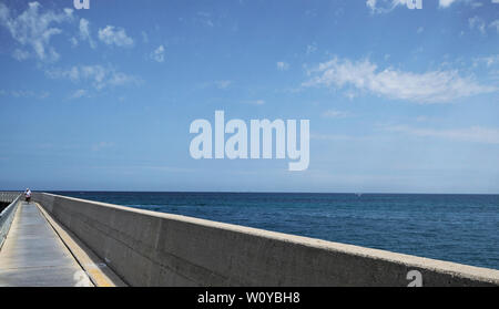 Straße entlang des Fano Hafens mit der Adria und einem Radfahrer im Hintergrund, Marken, Italien Stockfoto