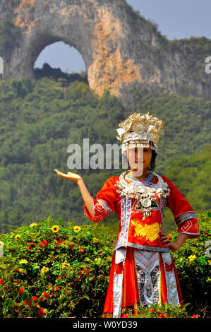 Ein chinesisches Mädchen posiert im lokalen ethnischen Kleid vor Moon hill Guilin, Yangshuo, China Stockfoto