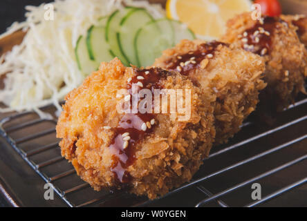Japanische Deep fried Pork chop oder menchikatsu Stil mit Soße und Salat. Stockfoto