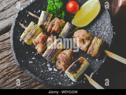 Im japanischen Stil Spieße Hähnchen Fleisch gegrillt oder Yakitori izakaya Essen in der Platte dienen mit grauem Ton Beleuchtung. Stockfoto