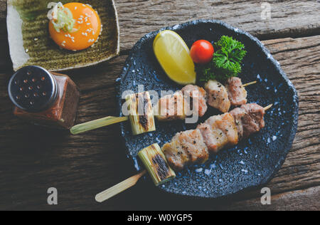 Im japanischen Stil Spieße Schwein gegrillt oder buta yakiton izakaya Essen in der Platte mit grauem Ton Beleuchtung. Stockfoto