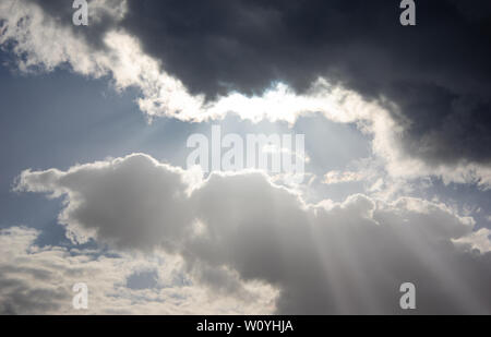 Sonnenstrahlen durch Gewitterwolken brechen Stockfoto