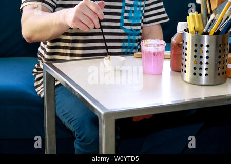 Mann Maler ist das Mischen von Farben vor dem malerei Kunst lack Studio. Künstler in seiner Hand hält Pinsel Farbe Ölfarben für Malerei auf der Palette gemischt. Stockfoto