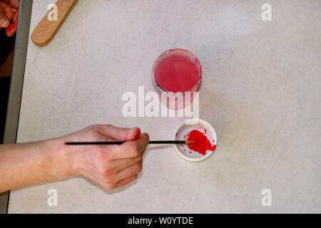 Mann Maler ist das Mischen von Farben vor dem malerei Kunst lack Studio. Künstler in seiner Hand hält Pinsel Farbe Ölfarben für Malerei auf der Palette gemischt. Stockfoto