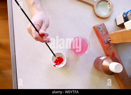 Mann Maler ist das Mischen von Farben vor dem malerei Kunst lack Studio. Künstler in seiner Hand hält Pinsel Farbe Ölfarben für Malerei auf der Palette gemischt. Stockfoto