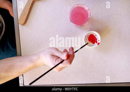 Mann Maler ist das Mischen von Farben vor dem malerei Kunst lack Studio. Künstler in seiner Hand hält Pinsel Farbe Ölfarben für Malerei auf der Palette gemischt. Stockfoto