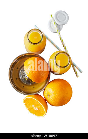 Frische Orangen für Orangensaft auf einem manuellen Squeezer gepressten mit zwei vollen Glas Flaschen neben auf Weiß in einem Top-down-Sicht isoliert Stockfoto