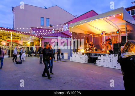Minsk, Weißrussland - 30. Juni 2018: Die Menschen gehen auf die Straße mit bunten Girlanden in Minsk Altstadt bei Nacht. Minsk, Weißrussland Stockfoto