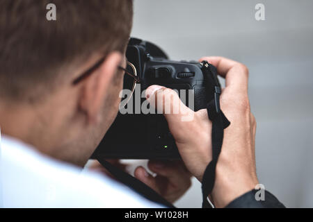 Digitale Spiegelreflexkamera in der Hand. Fotograf shooting Hände schließen. Mann Fotograf macht Fotos für Stock Fotografie. Männliche Hände halten Stockfoto