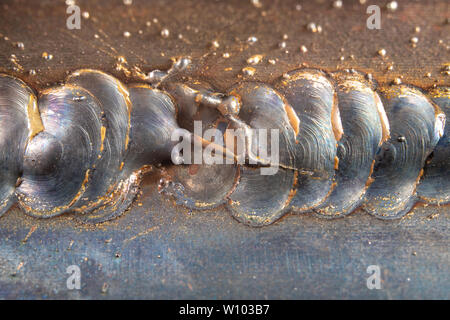 Die Kehlschweißung wird mit der MAG-Methode gelegt. Fehler in Stahl Verbindungen mittels arc welding. dunklen Hintergrund. Stockfoto