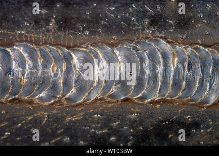 Die Kehlschweißung wird mit der MAG-Methode gelegt. Fehler in Stahl Verbindungen mittels arc welding. dunklen Hintergrund. Stockfoto