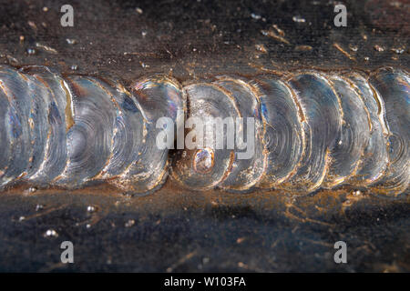 Die Kehlschweißung wird mit der MAG-Methode gelegt. Fehler in Stahl Verbindungen mittels arc welding. dunklen Hintergrund. Stockfoto