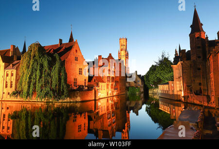 Berühmte Ansicht von Brügge touristische Sehenswürdigkeiten Attraktion - rozenhoedkaai Kanal mit Glockenturm und alte Häuser am Kanal mit Baum in der Nacht. Brügge, Belgien. Stockfoto