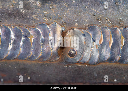 Die Kehlschweißung wird mit der MAG-Methode gelegt. Fehler in Stahl Verbindungen mittels arc welding. dunklen Hintergrund. Stockfoto