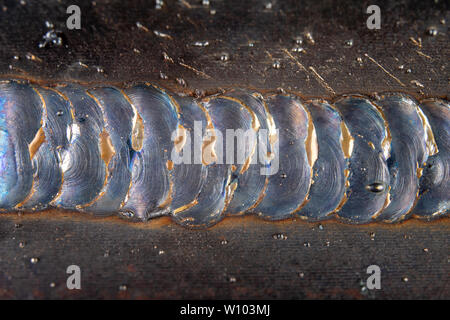 Die Kehlschweißung wird mit der MAG-Methode gelegt. Fehler in Stahl Verbindungen mittels arc welding. dunklen Hintergrund. Stockfoto