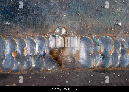 Die Kehlschweißung wird mit der MAG-Methode gelegt. Fehler in Stahl Verbindungen mittels arc welding. dunklen Hintergrund. Stockfoto