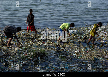 Kinder sammeln Kunststoffe in einem Reservoir von Müll in Lhokseumawe, Aceh. von Greenpeace Daten, Abfallerzeugung in Indonesien 65 Millionen Tonnen pro Jahr erreicht ist verschmutzt. Indonesien ist das zweitgrößte Land der Welt für Kunststoffabfälle, die Produktion nach China. Stockfoto