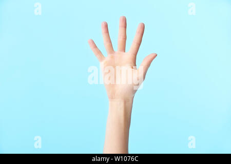 Menschliche Hand zeigt die Nummer Fünf, auf blauem Hintergrund isoliert Stockfoto