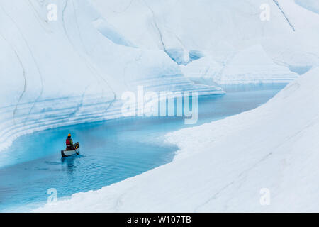 Ein Mann Paddles solo auf einer aufblasbaren Kanu hinunter eine noch Wasser Fluss auf der Matanuska Gletscher in der alaskischen Wildnis. Stockfoto