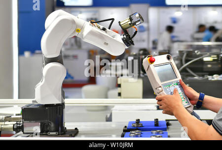 Techniker überprüfen und Steuerung Automatisierung Robot Arm Maschine für Automotive Lager Verpackungsprozess im Werk. Stockfoto