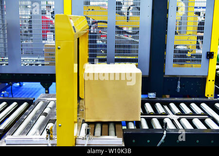 Kartons auf Förderband im Versandlager. Pakete Transport System Konzept. Stockfoto