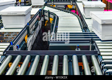 Kartons auf Förderband im Versandlager. Pakete Transport System Konzept. Stockfoto