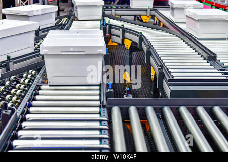 Kartons auf Förderband im Versandlager. Pakete Transport System Konzept. Stockfoto