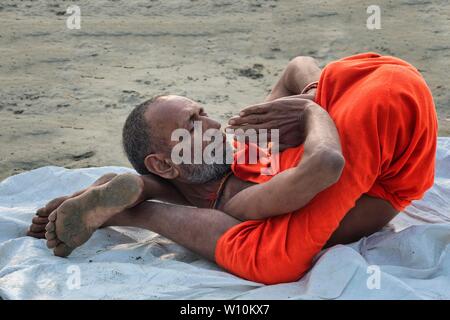 Sadhu Yoga bei Sonnenaufgang auf dem Ganges Ufer, Allahabad Kumbh Mela, der weltweit größte religiöse Versammlung, Uttar Pradesh, Indien Stockfoto