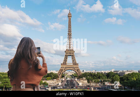 Reisende Frau unter Foto von Eiffel Turm, Wahrzeichen und Reiseziel in Paris, Frankreich durch Mobile Smartphone Stockfoto