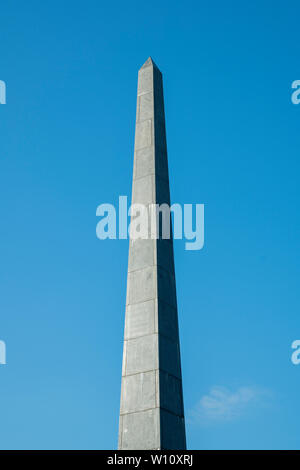 Stein Obelisk gegen den blauen Himmel. verticalphoto. Stockfoto