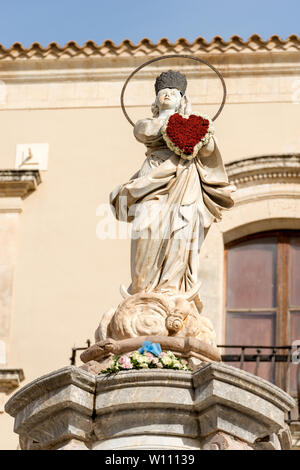 Marmor statue der Jungfrau Maria mit einem Herz aus Blumen in der kleinen Stadt Noto, Syrakus, Sizilien, Italien, Europa Stockfoto