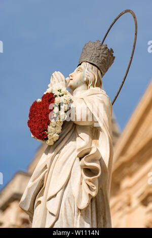 Marmor statue der Jungfrau Maria mit einem Herz aus Blumen in der kleinen Stadt Noto, Syrakus, Sizilien, Italien, Europa Stockfoto