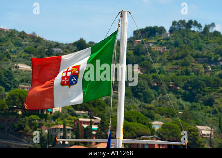 Italienische Flagge mit Wappen der vier Seerepubliken, Venedig, Genua, Pisa und Amalfi hängen auf einem Schiff mast. Grüne Hügel im Hintergrund Stockfoto