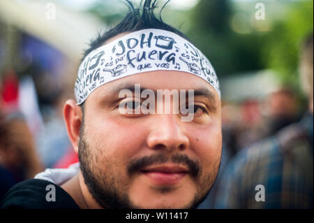 Tegucigalpa, Honduras. 29 Juni, 2019. Ein Mann trägt ein Stirnband, das liest "Joh" Credit: Camilo Freedman/ZUMA Draht/Alamy leben Nachrichten Stockfoto